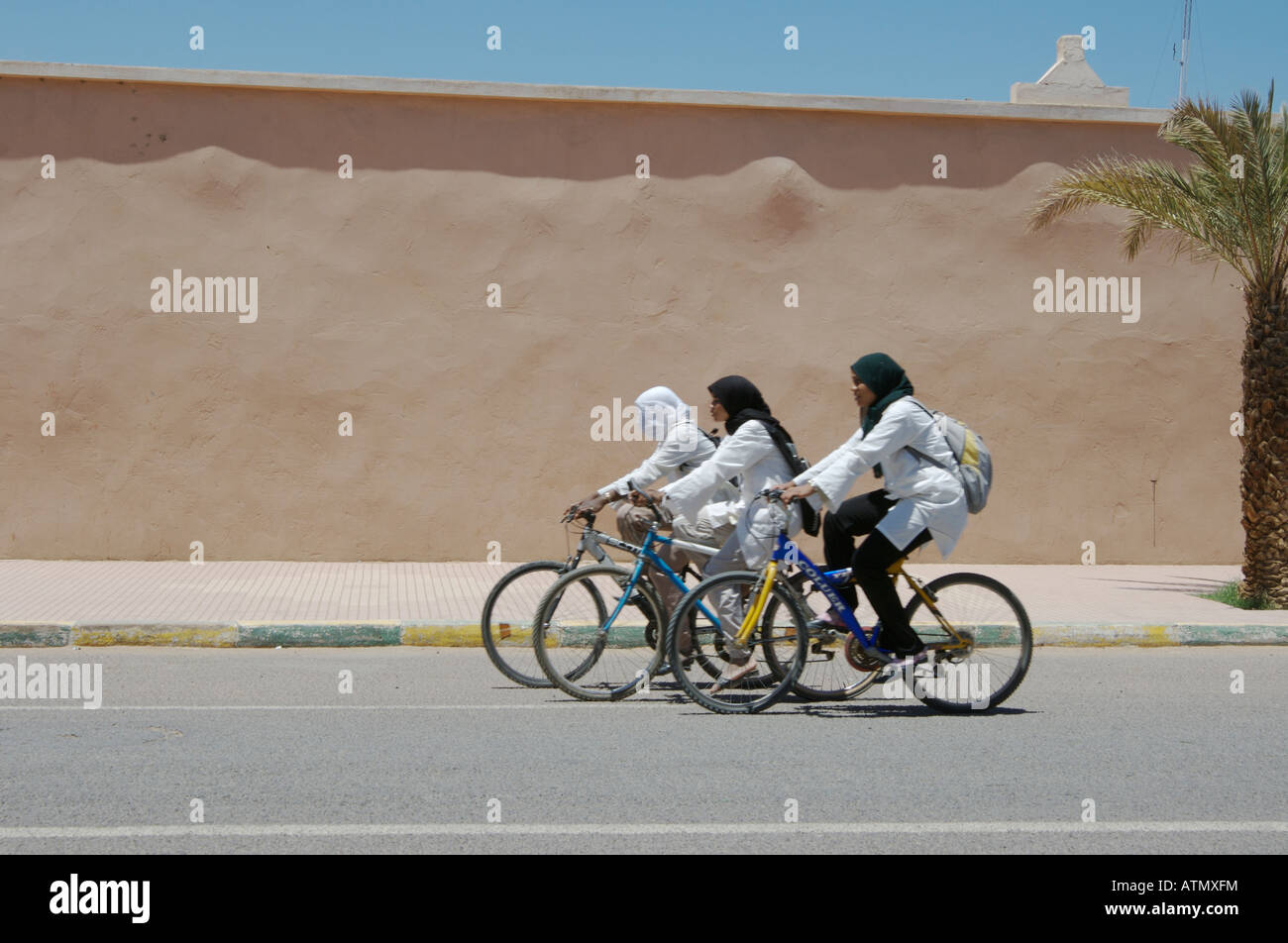 Drei Schülerinnen, die in islamischer Kleidung zur Schule fahren. Zagora, Marokko Stockfoto
