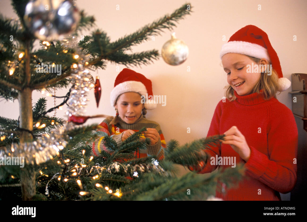Zwei Mädchen schmücken einen Weihnachtsbaum Stockfoto