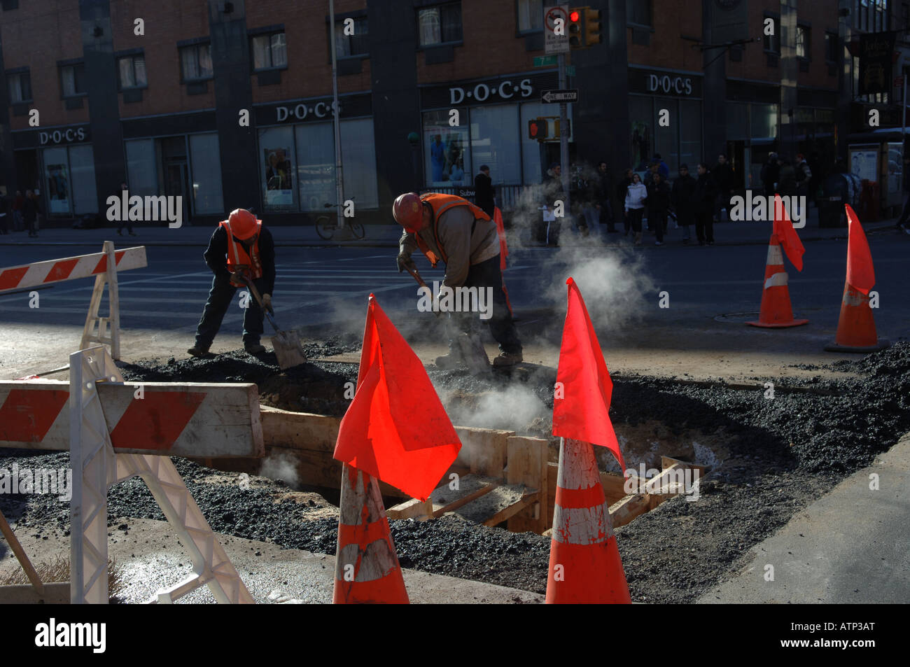 Bauarbeiter patch eine Ausgrabung Loch auf West 23rd Street im Stadtteil NYC Chelsea Stockfoto