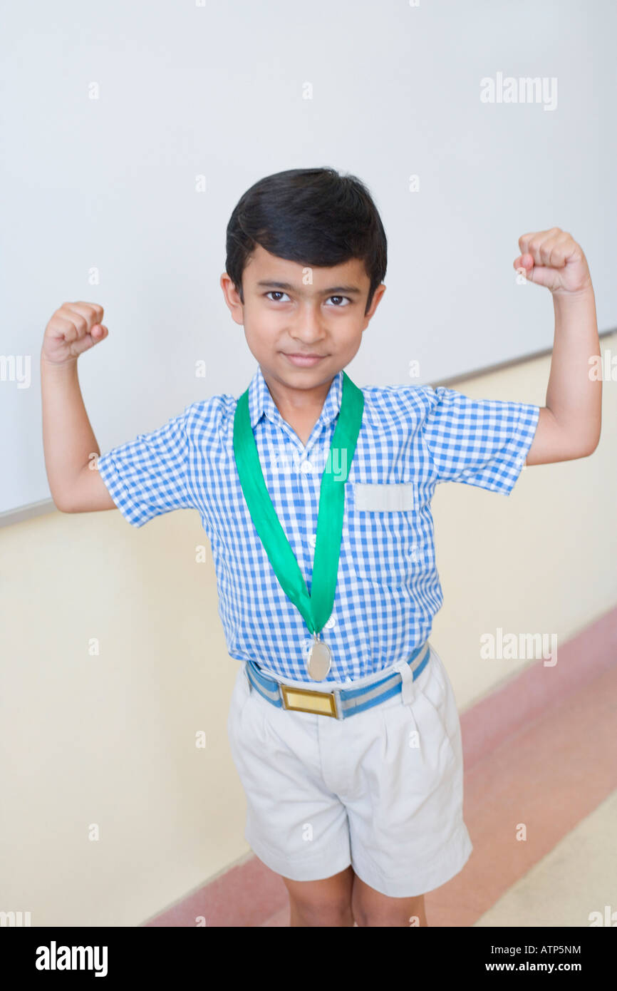 Schuljunge mit einer Medaille um seinen Hals und beugen, Muskeln Stockfoto
