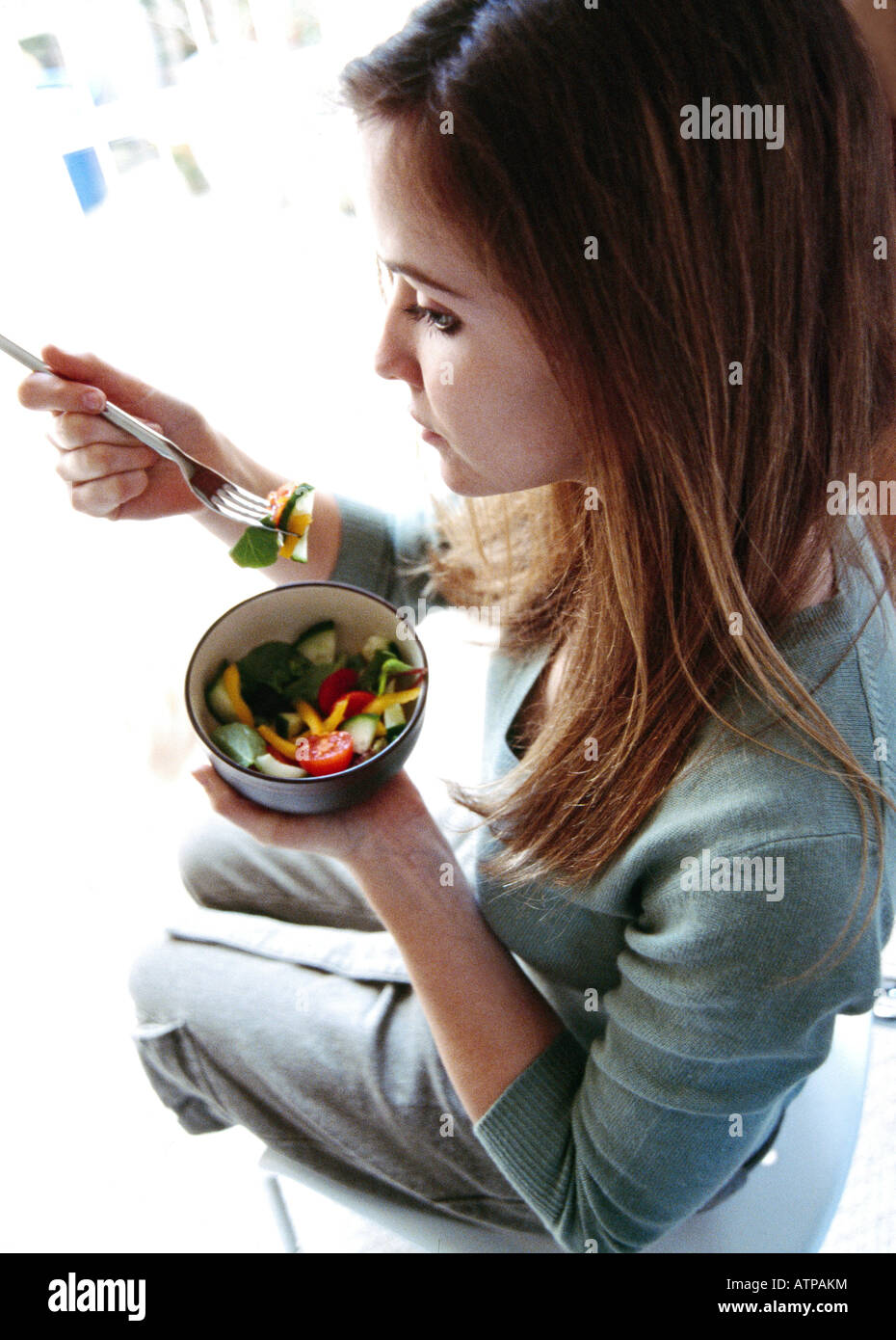 Junge Frau essen Salat Stockfoto