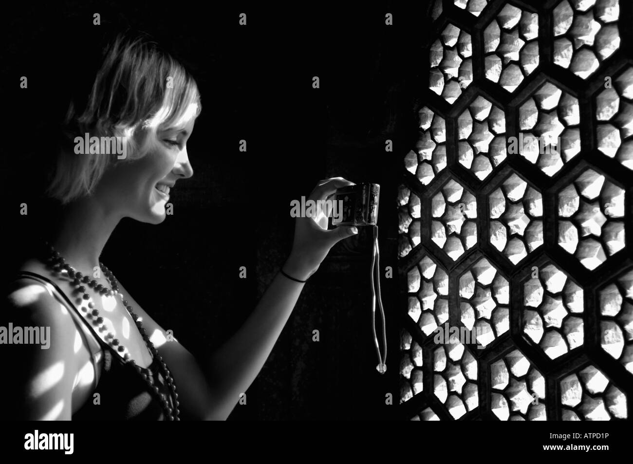 Seitenansicht einer jungen Frau, die eine Aufnahme durch Fenster mit einer digitalen Kamera, Taj Mahal, Agra, Uttar Pradesh, Indien Stockfoto