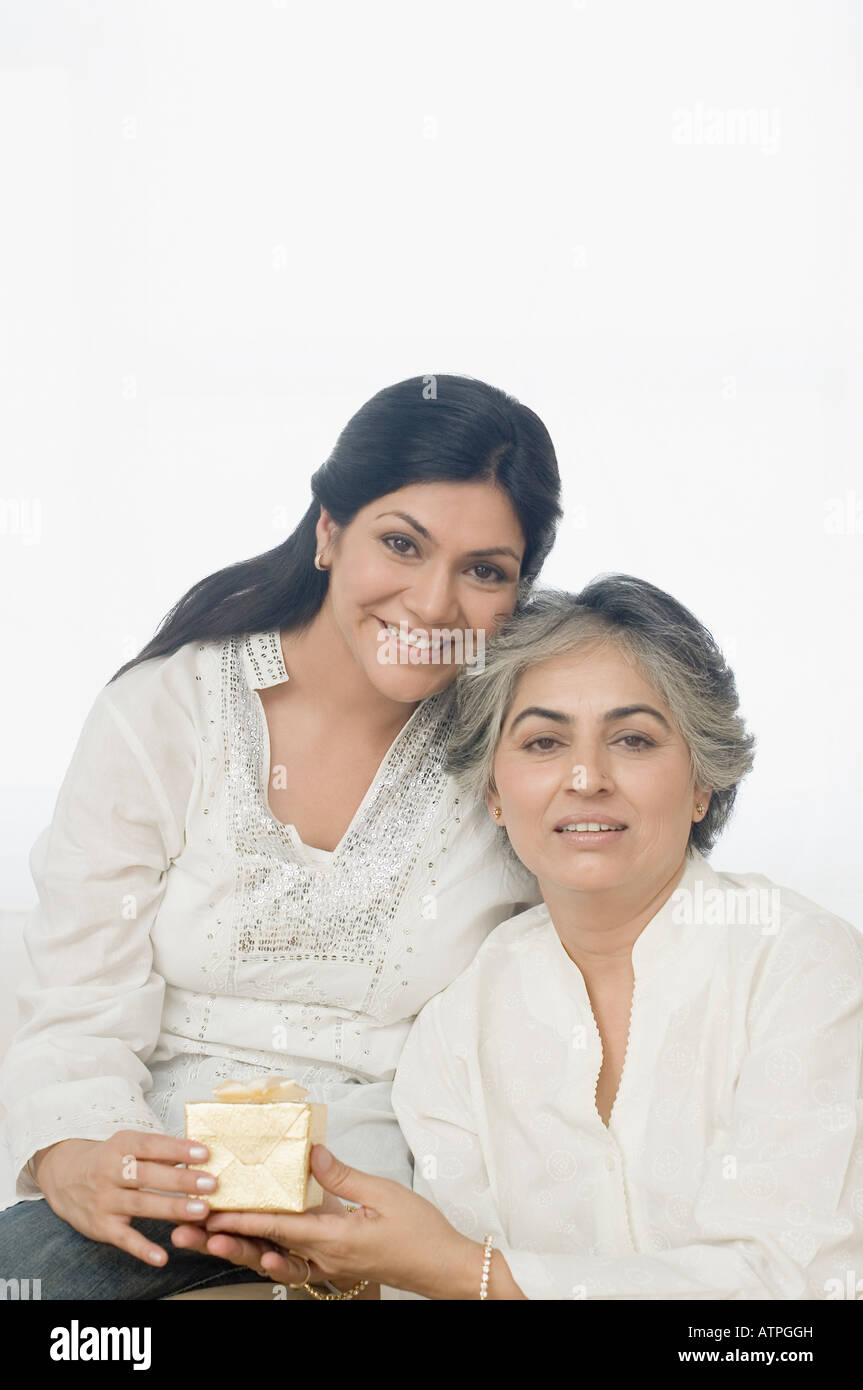 Porträt einer Mitte Erwachsene Frau ein Geschenk zu ihrer Mutter und lächelte Stockfoto