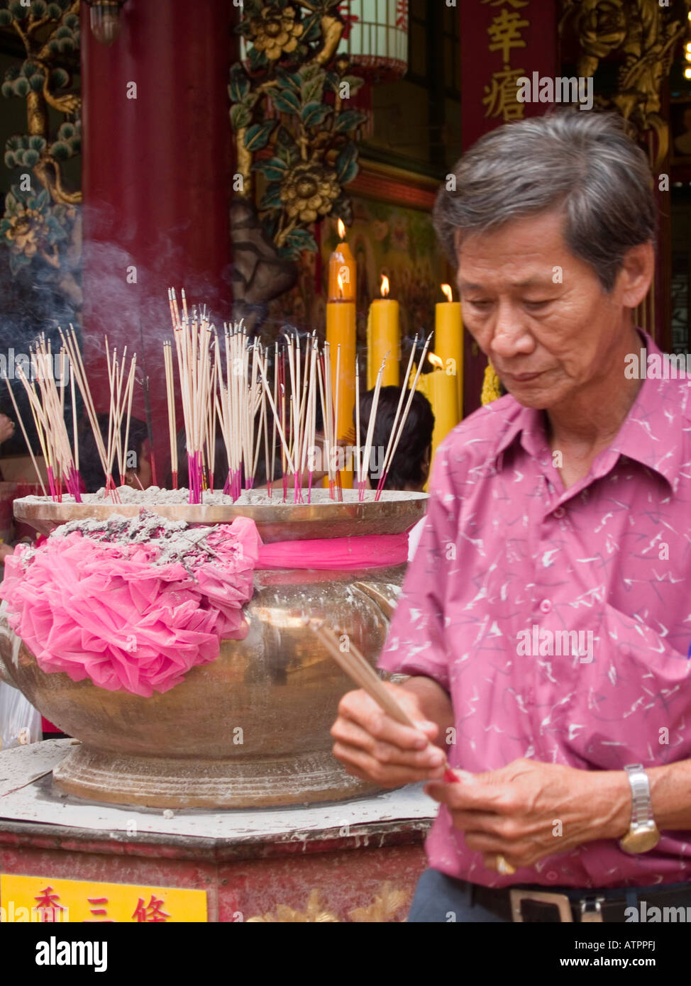 Mann Beleuchtung Weihrauch als Glücksbringer in einem Schrein während Chinese New Year in Bangkok Stockfoto