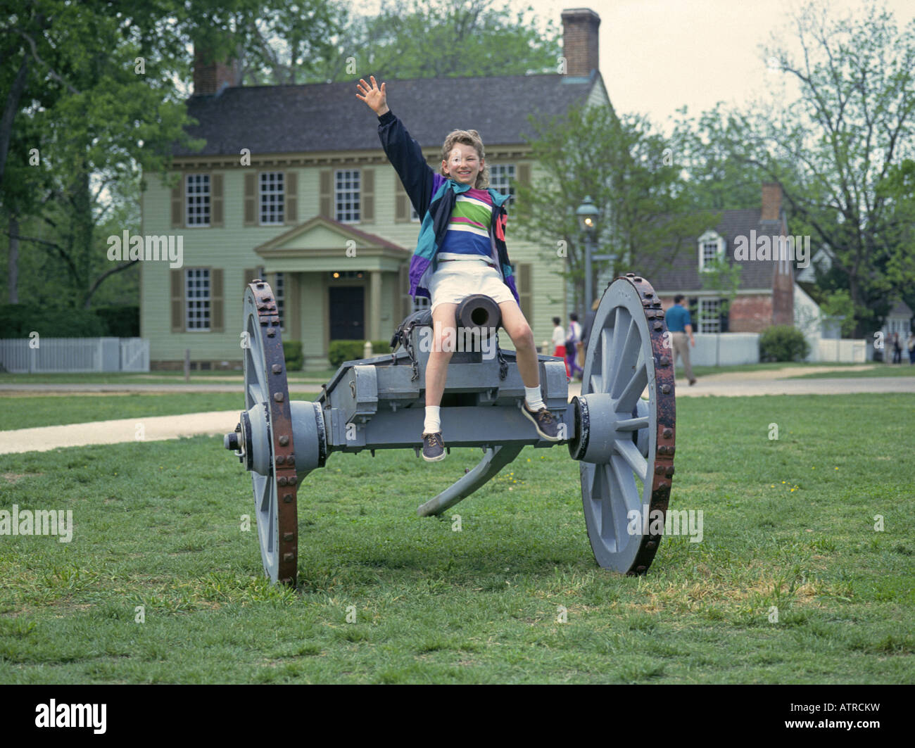 Ein junger Besucher spielt auf eine alte Kanone in den wichtigsten Platz der alten Colonial Williamsburg Stockfoto