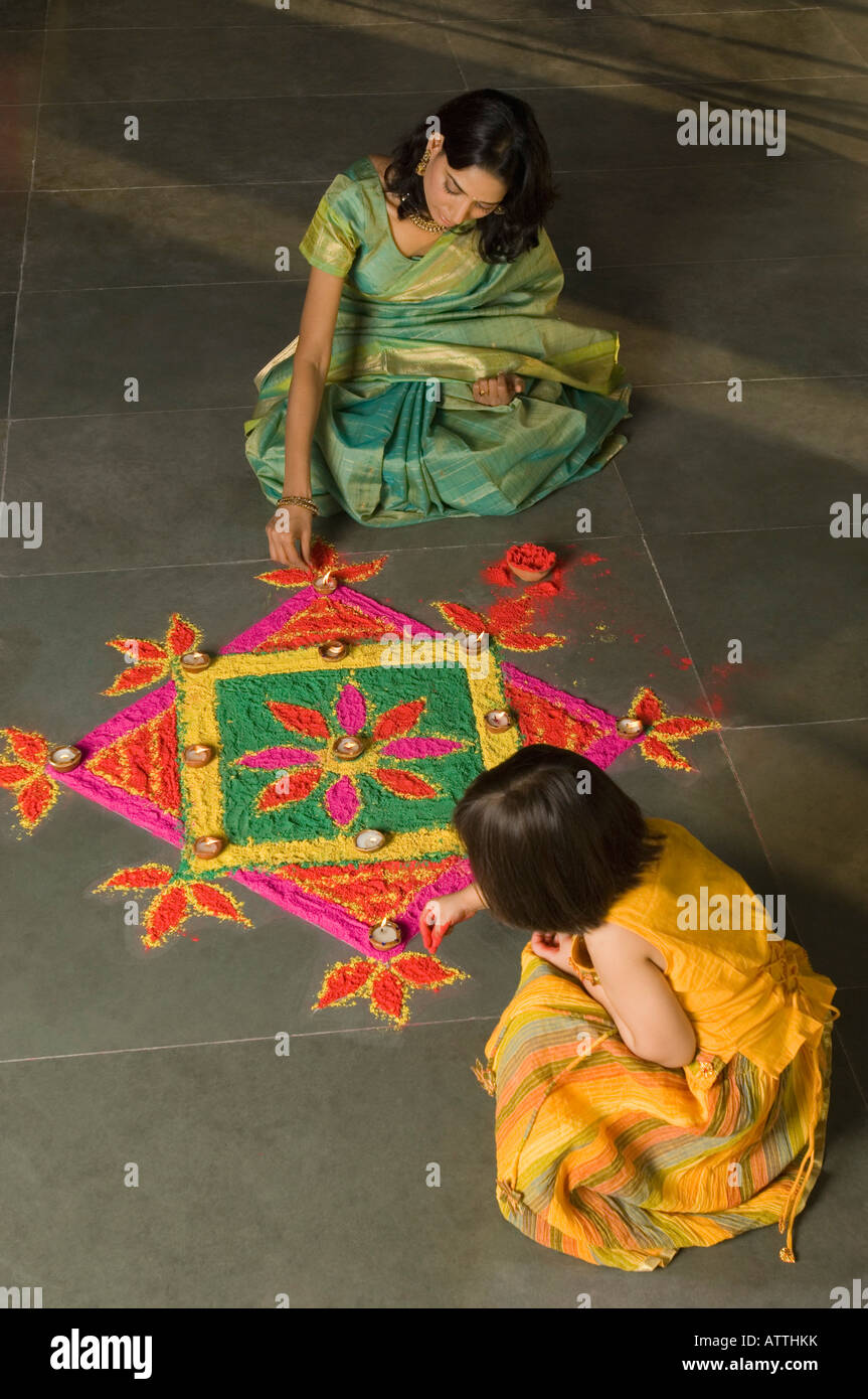 Erhöhte Ansicht einer jungen Frau macht Rangoli mit ihrer Tochter Stockfoto