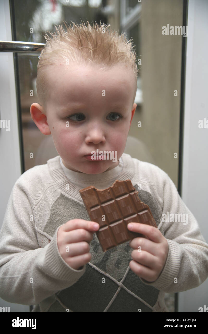 Ein Kleinkind Essen eine große Tafel Milchschokolade Stockfoto