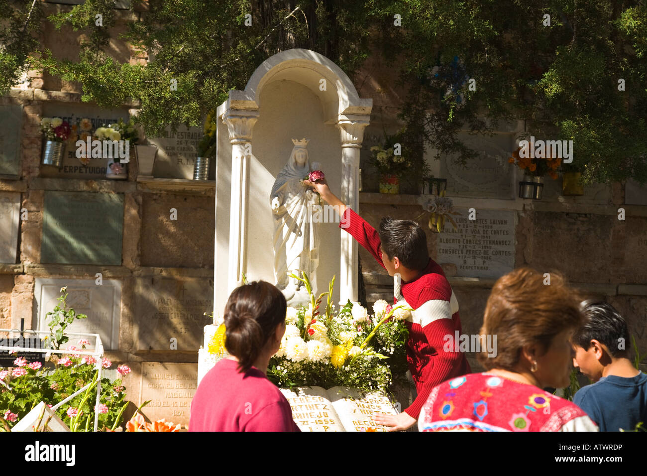 Mexiko Guanajuato junge mexikanische männlichen Ort Blume in der Hand der Statue Tag der toten Feier am Grab Frauen im Friedhof Stockfoto