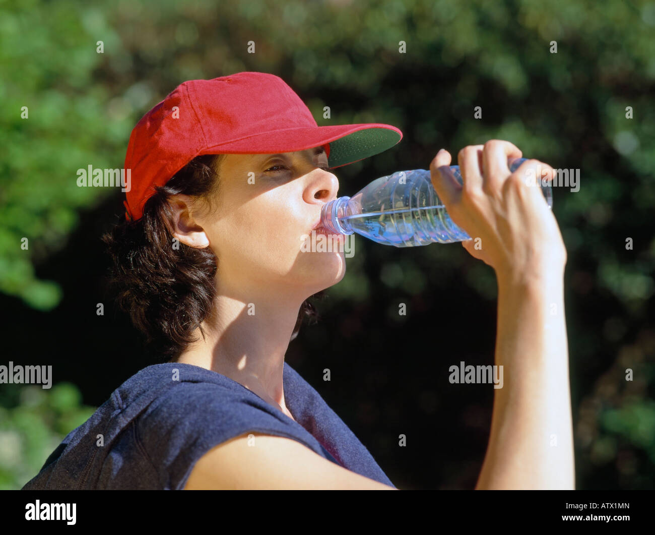 Junge Frau trinkt Mineralwasser Stockfoto
