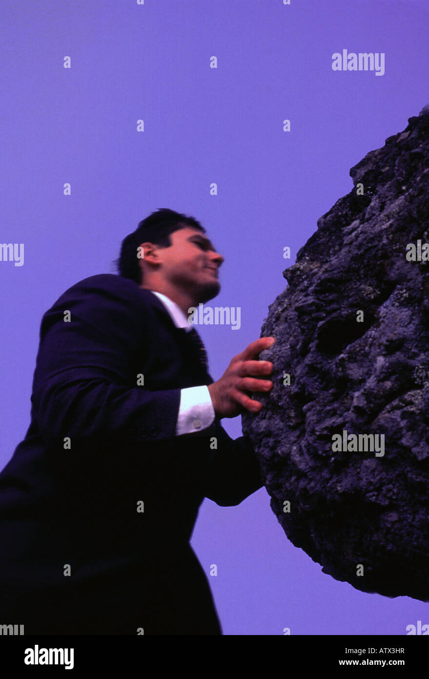 Kaukasische Business-Mann schob einen Felsen Stockfoto
