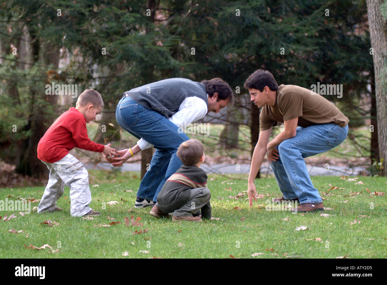 Männliche Mitglieder einer Großfamilie spielen Fußball in ihrem Vorgarten am Thanksgiving day Stockfoto
