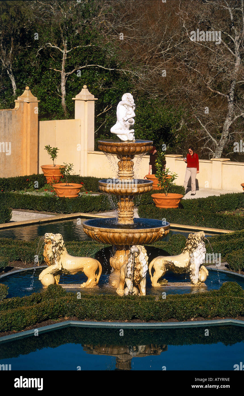 Eine Frau zu Fuß rund um den italienischen Renaissance-Garten verfügt über einen großen und dekorativen Wasser Brunnen in der Mitte umgeben von symmetrischen Blumenbeeten in Hamilton Gardens Hamilton Stockfoto