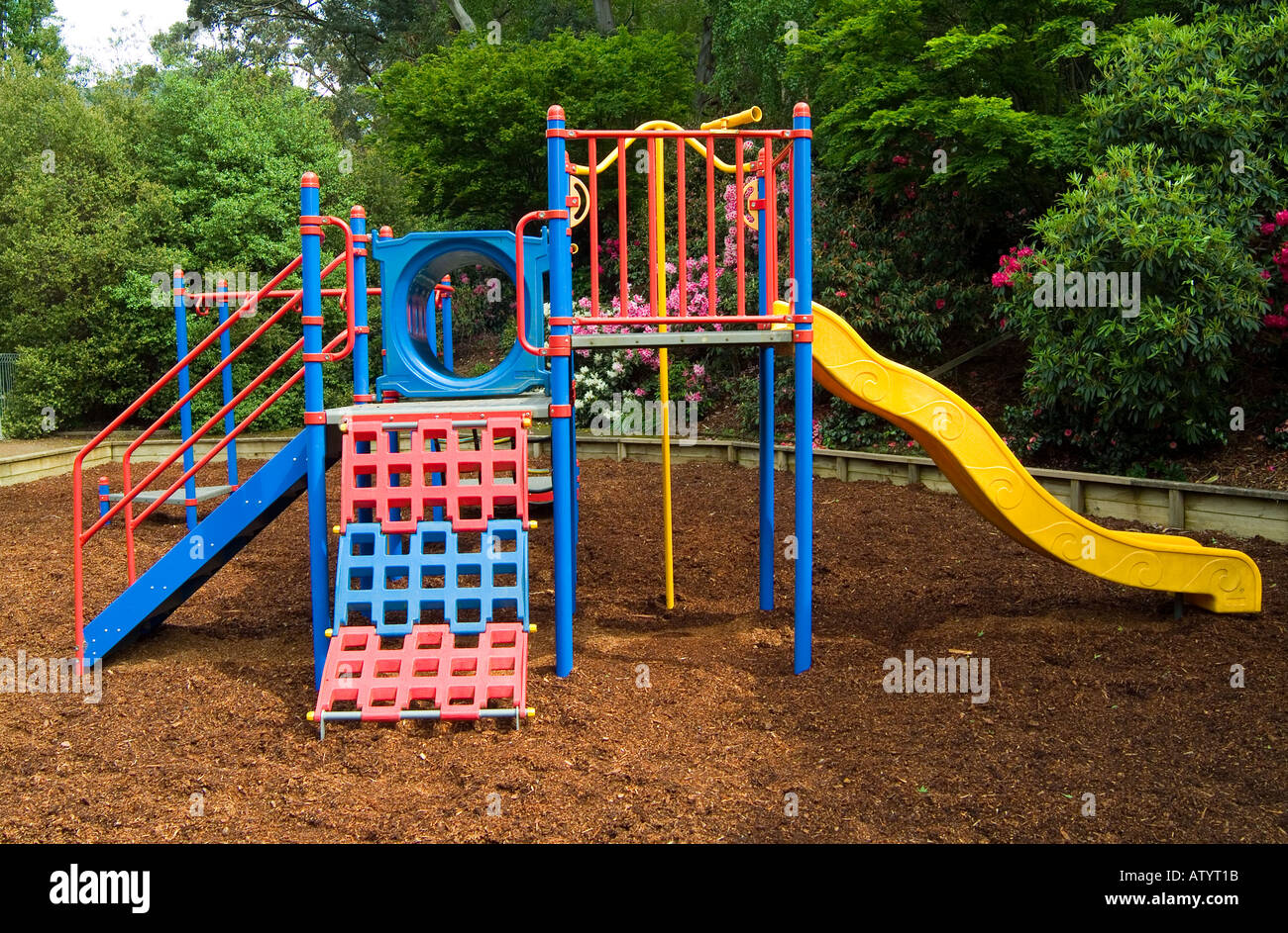 Bunte Kinder s Spielgeräte auf dem Spielplatz von Rinde Kiefernspäne geschützt Stockfoto