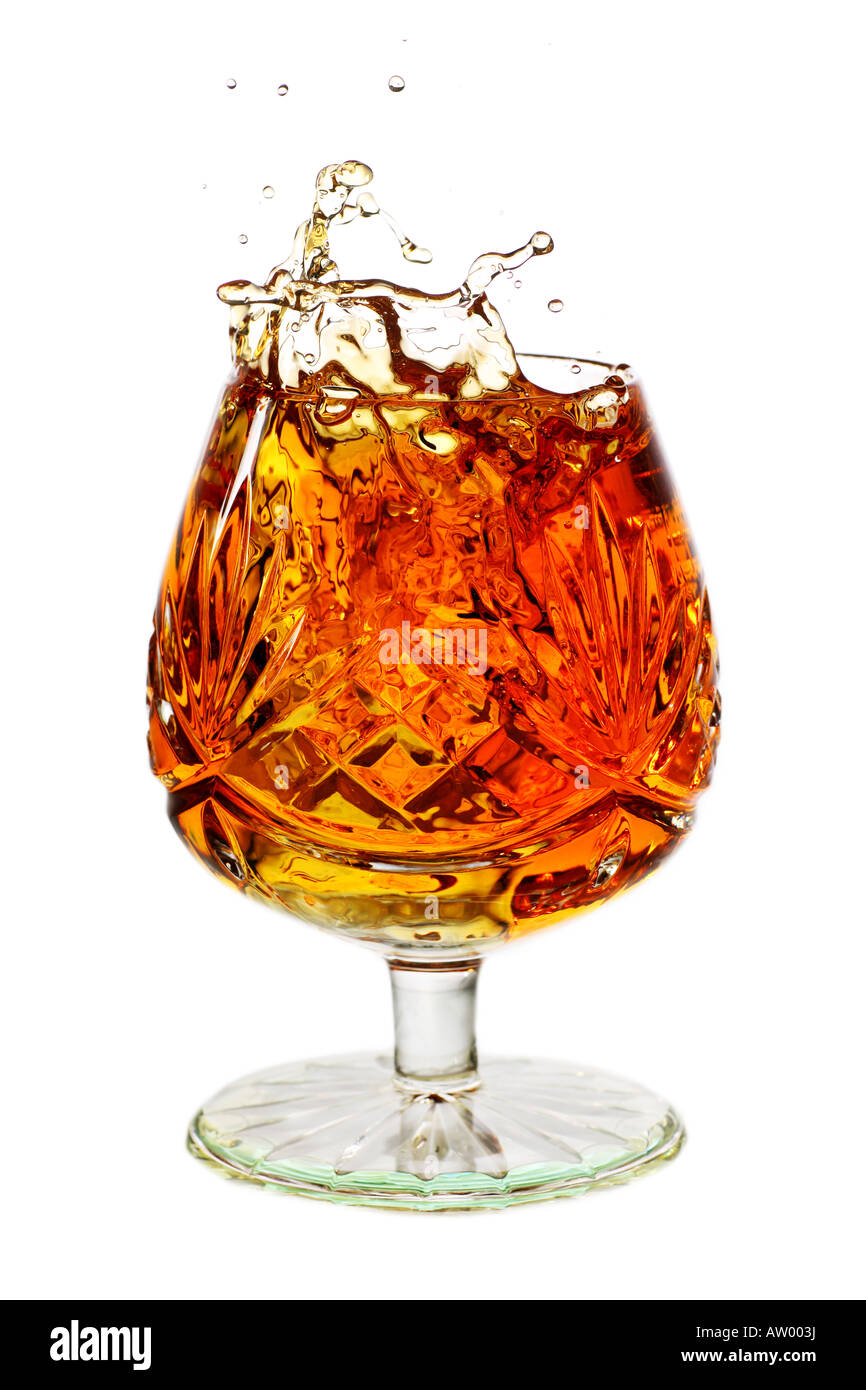 Cognac-Schwenker Glas randvoll mit Weinbrand und splash Stockfotografie