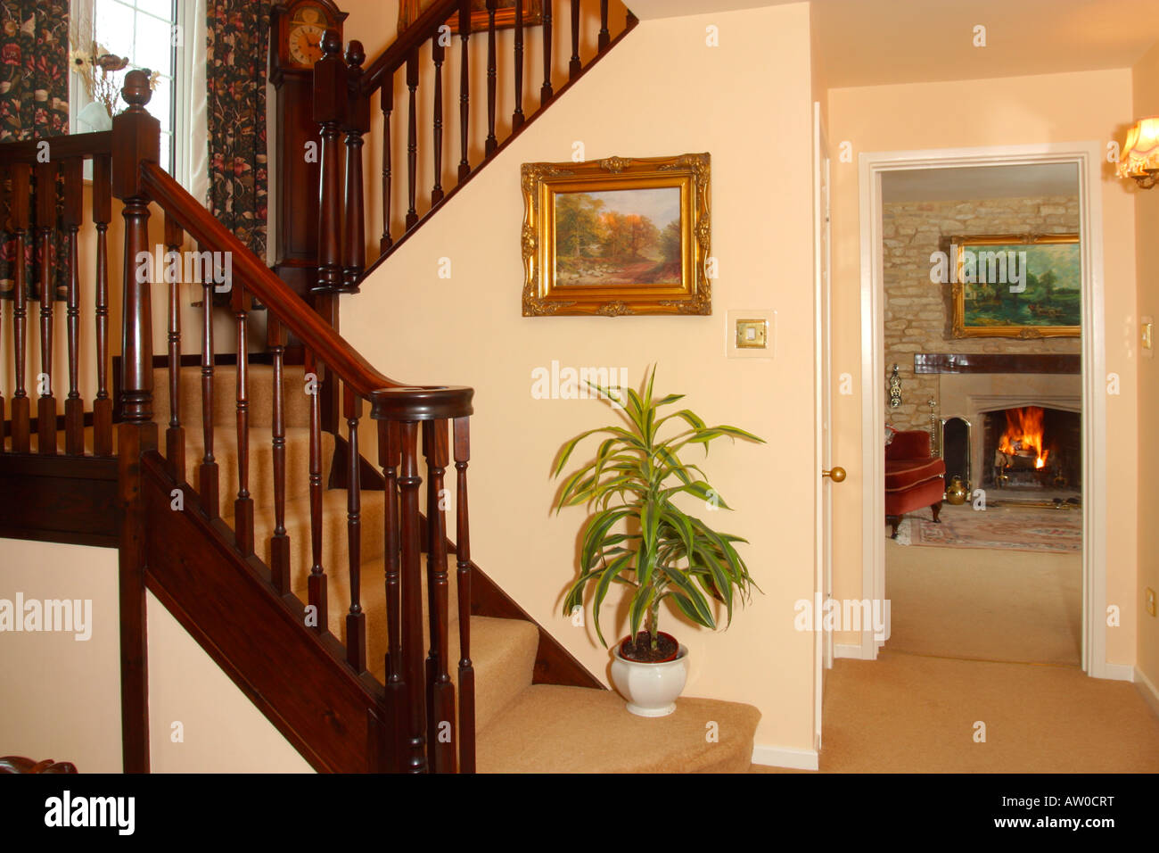 UK Property, Haus innen, traditionelle Halle Treppen und Anzeigen Feuer im Wohnzimmer zu öffnen. Stockfoto