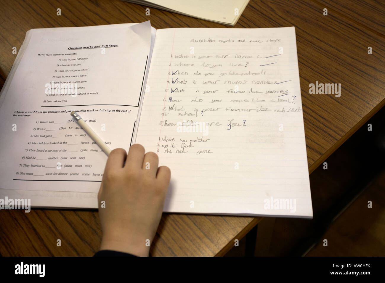 Schulkind ausfüllen Englisch Klassenarbeiten in der Grundschule Belfast Nordirland Vereinigtes Königreich Stockfoto