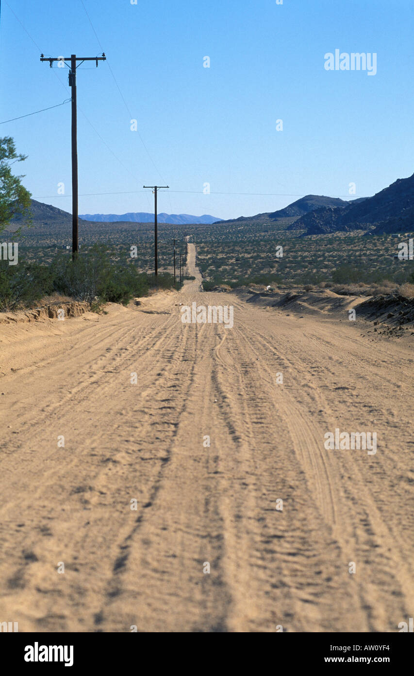 Leere Wüstenstraße, Telegrafenmasten und Mountains, Kalifornien Stockfoto