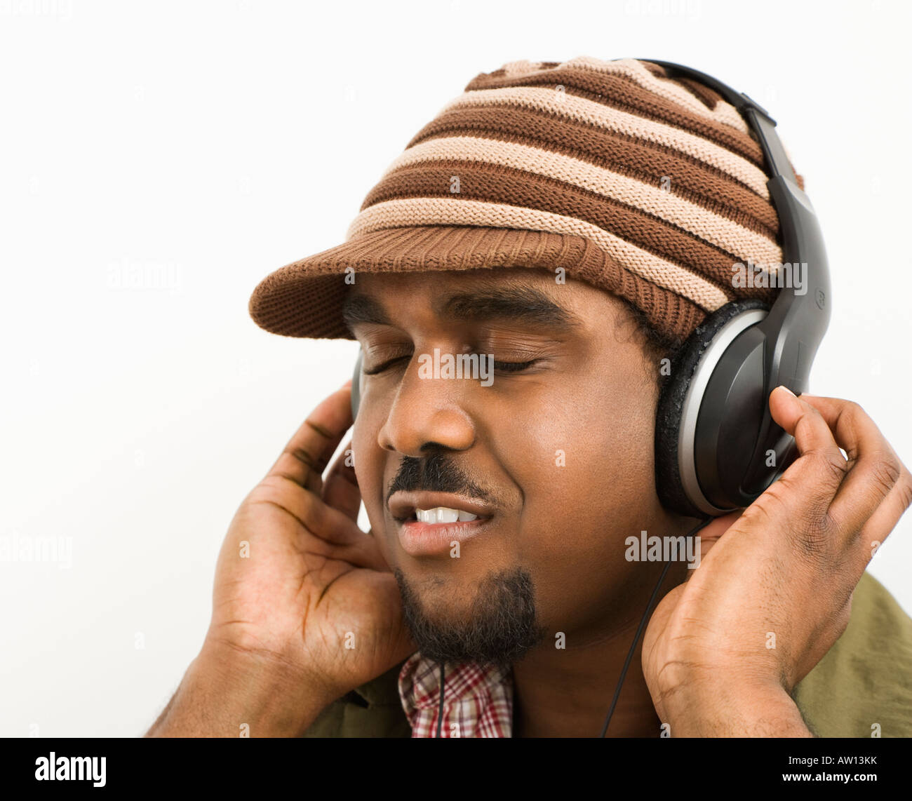 Afrikanischer Amerikaner Mitte erwachsenen Mann mit Stricken Hut und hören über Kopfhörer mit Augen geschlossen Stockfoto