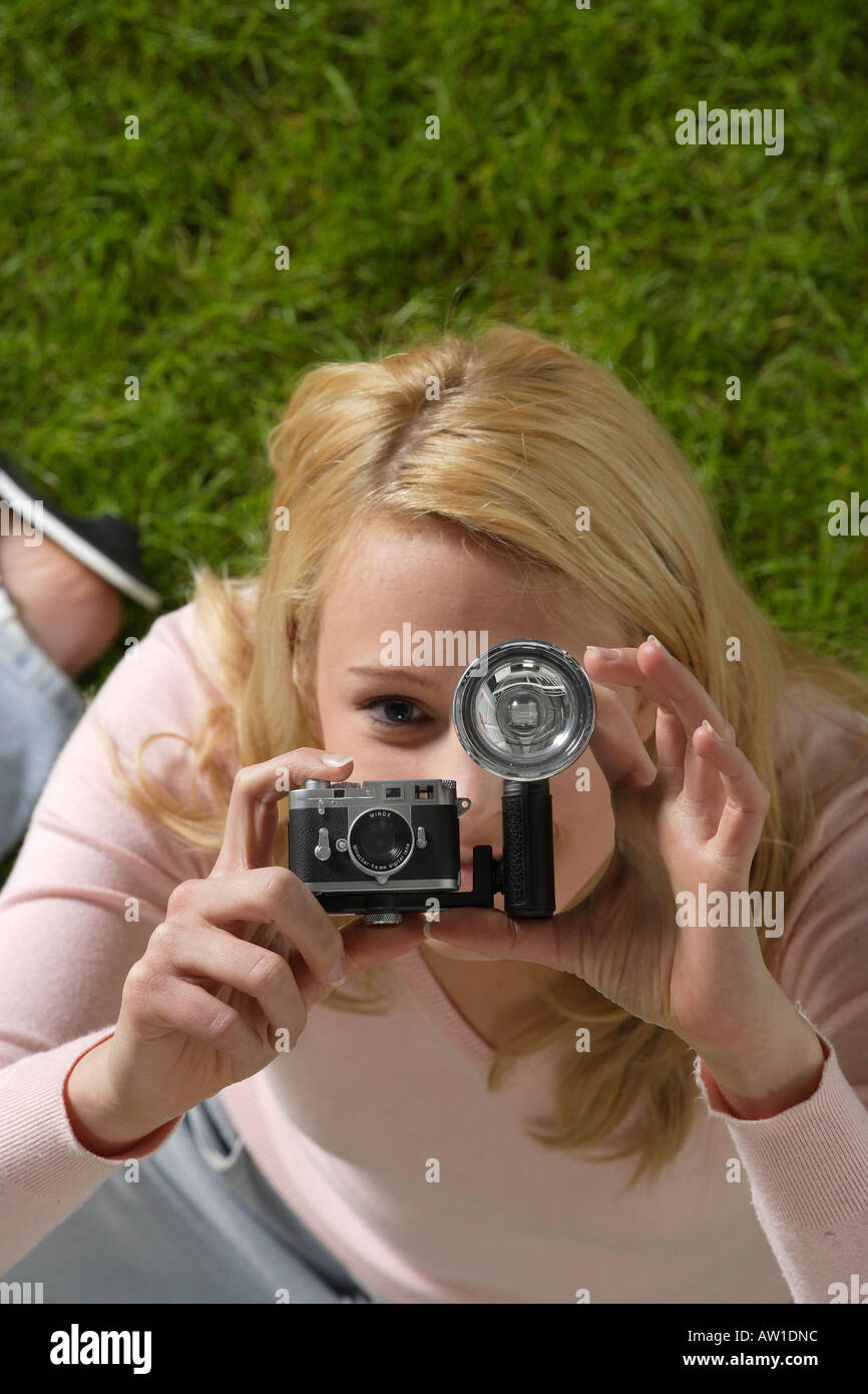 Blondewoman mit einer Kamera vor ihr Gesicht Stockfoto