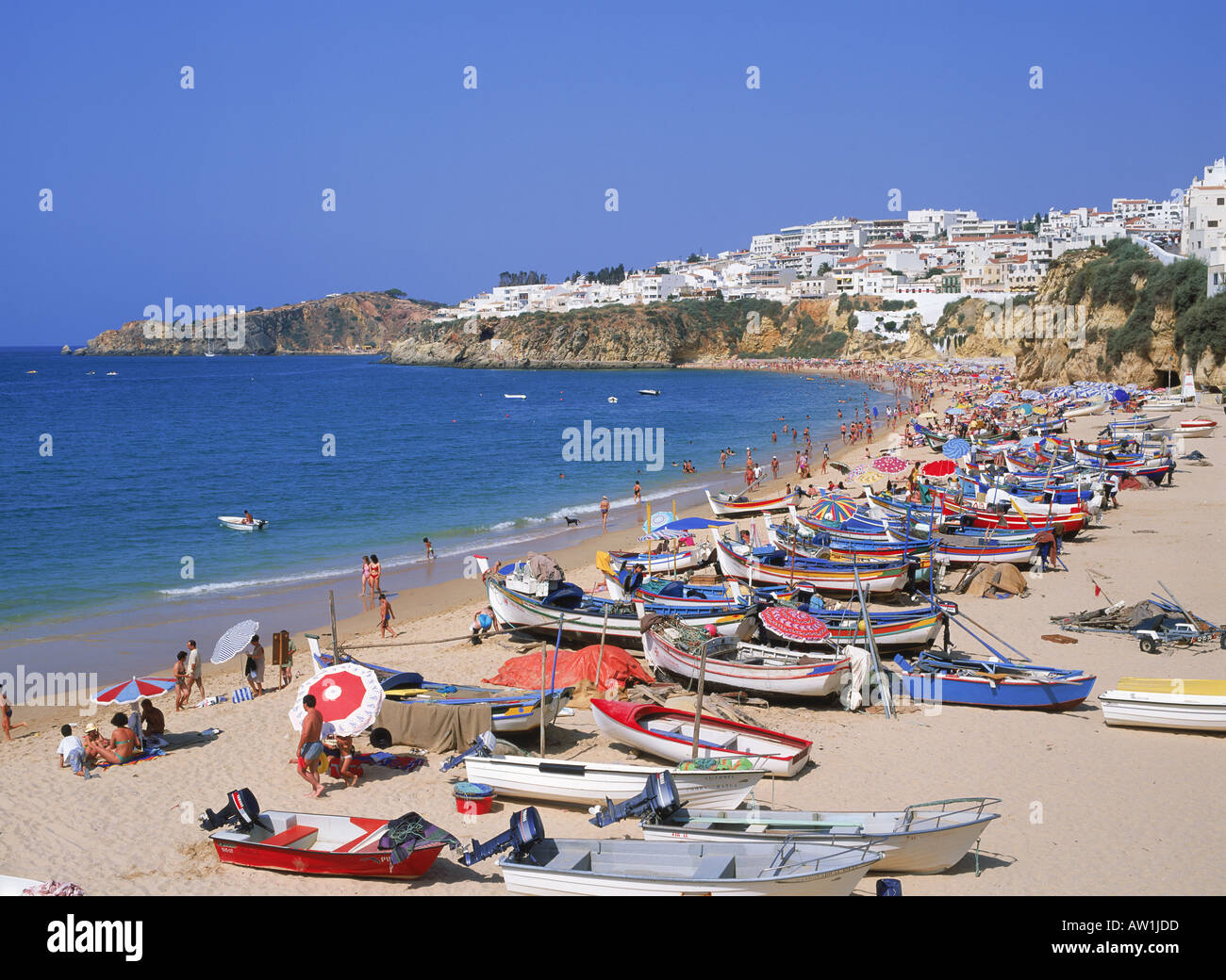 Bunte Fischerboote und Touristen am Strand von Albufeira an der Algarve, Portugal Stockfoto