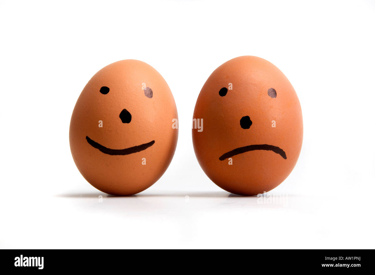 Bild zeigt zwei Eiern mit fröhlichen und traurigen Gesicht darauf. Stockfoto