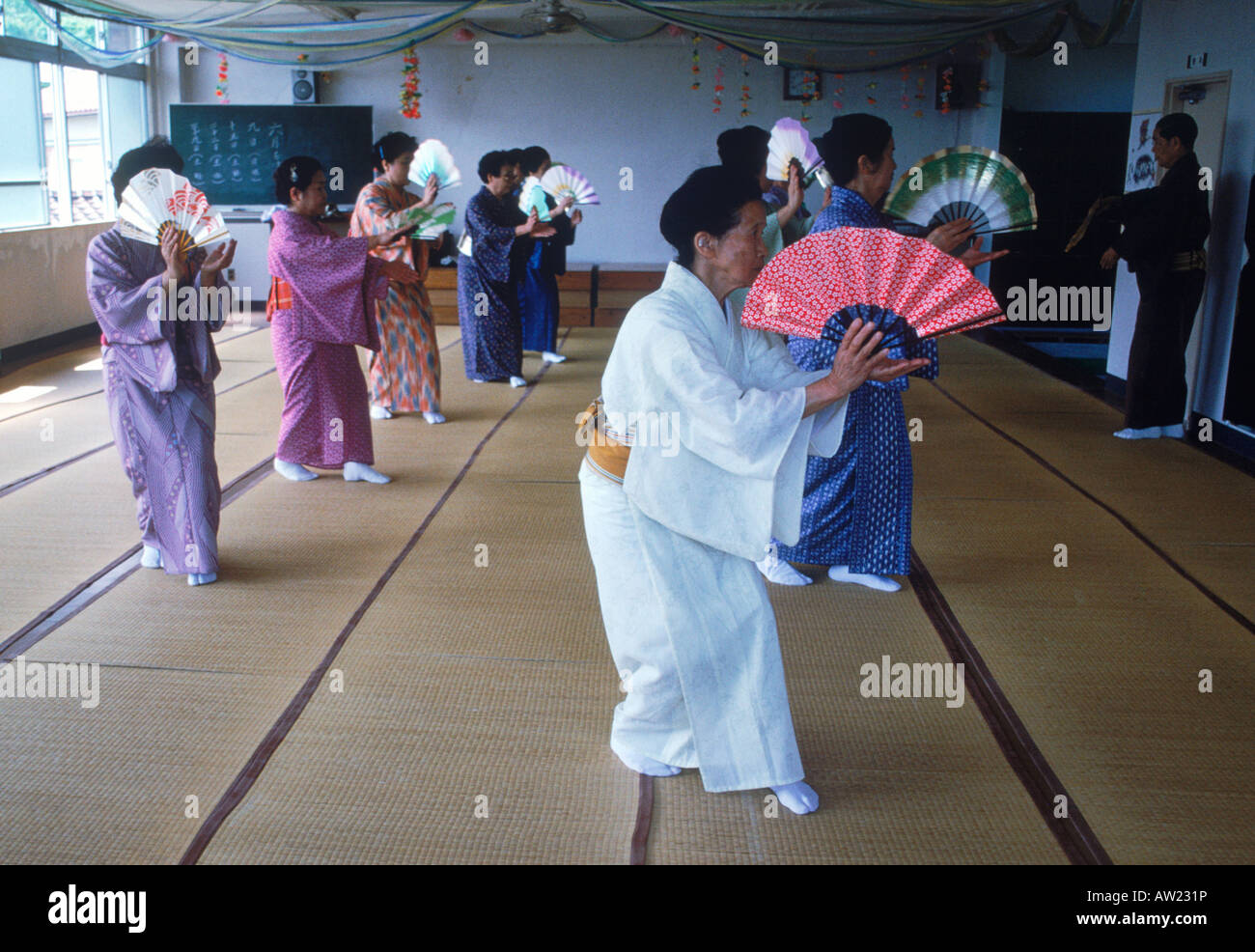 Ältere japanische Frauen, die die alte Kunst des Lüfters im Klassenzimmer tanzen lernen Stockfoto