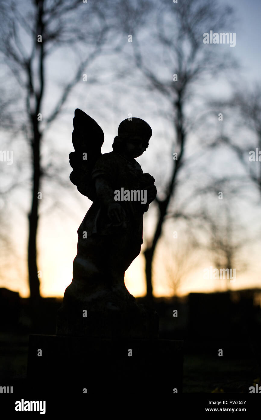 Silhouette der Engel Grabstein auf einem Friedhof bei Sonnenaufgang. UK Stockfoto