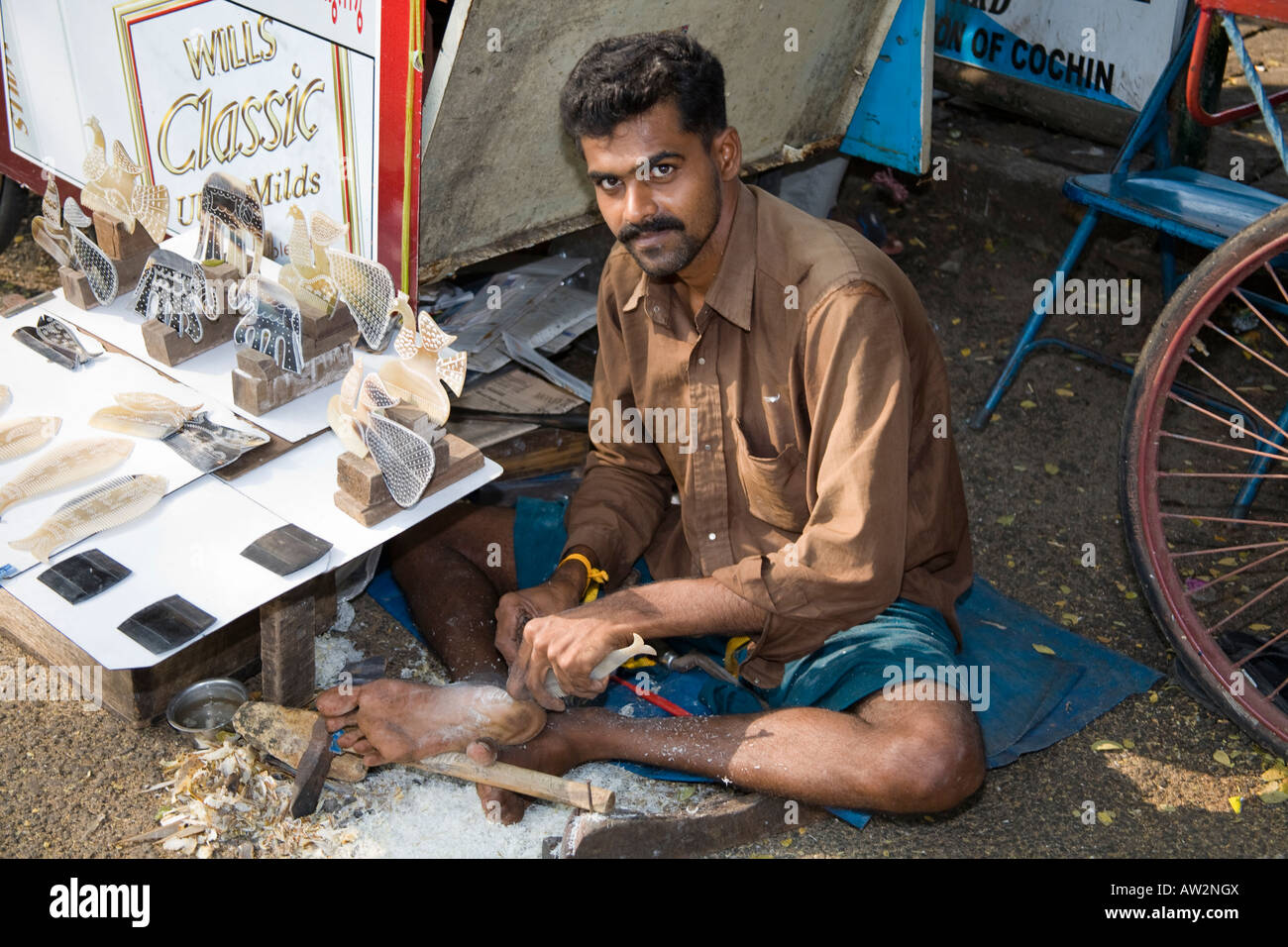 Mann schnitzen Fisch Ornament aus Kuh Horn, Fort Cochin, Cochin, Kerala, Indien Stockfoto
