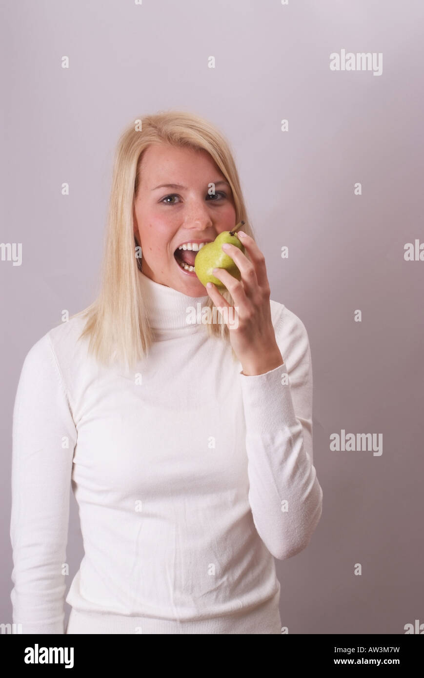 Blonde Frau essen eine Birne | Blonde Junge Frau Isst Ein Birne Stockfoto