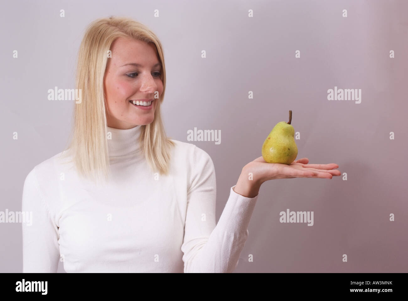 Lächelnde Frau mit einer Birne | Lächelnde Frau Mit Einer Birne Stockfoto