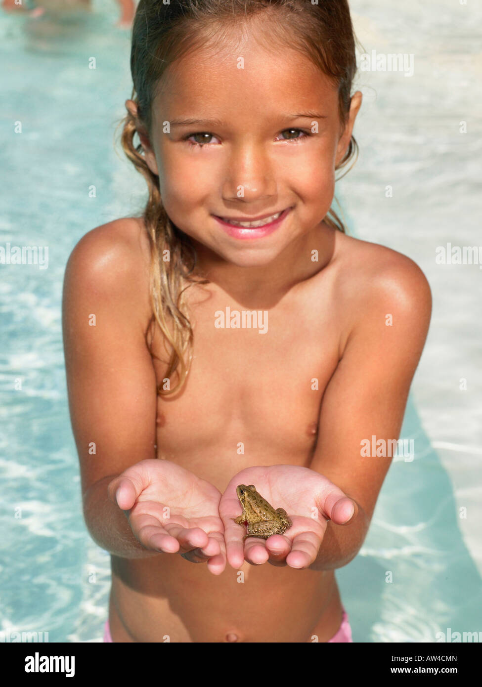 Kleines Mädchen hält einen Frosch. Stockfoto