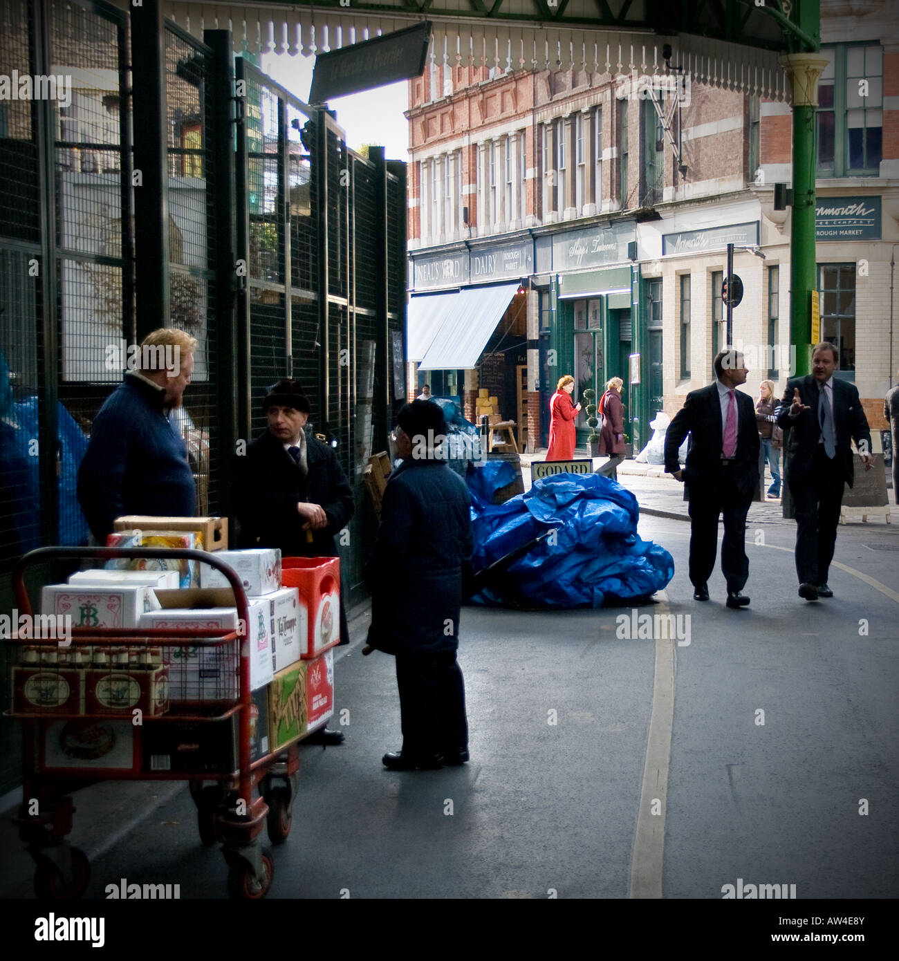 Quadratisches Format, Geschäftsleute, die zu Fuß durch traditionelle Borough Lebensmittelmarkt, London uk Stockfoto