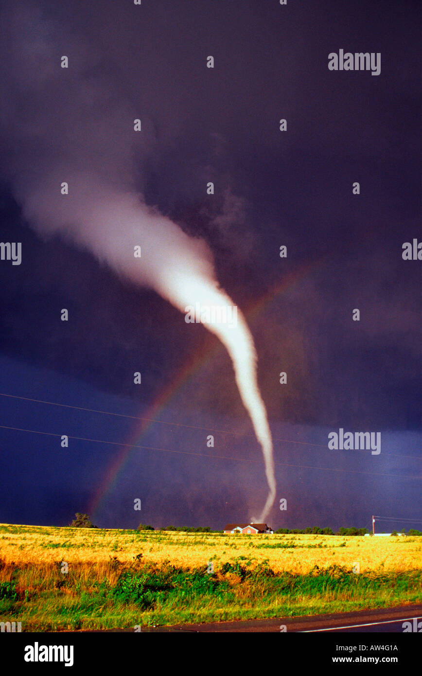 Sonne scheint hell auf einem Kansas-Feld als diese weiß ist F3 Tornado durch eine lebendige Regenbogen abgesetzt und verpasste nur ein Haus. Stockfoto