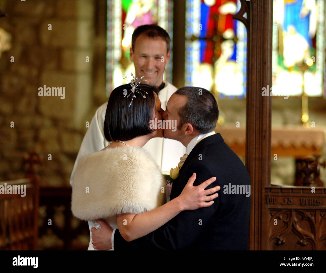 Ein paar Kuss auf den kirchlichen Gang nach dem Aufstehen verheiratet Modell veröffentlicht Stockfoto