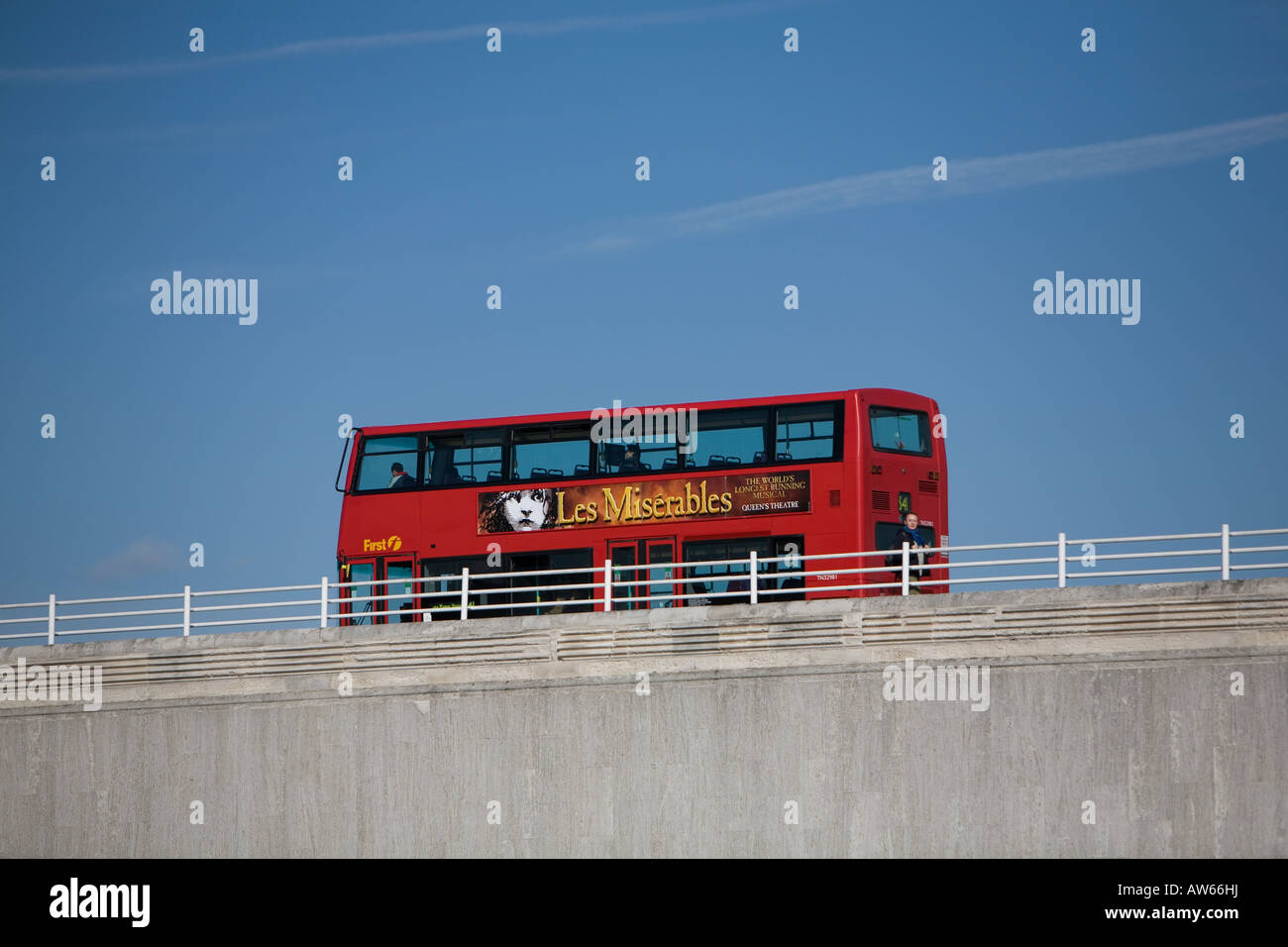 Ein roter Londoner Doppeldeckerbus überquert London Bridge über die Themse, die hit musical Les Misserable Werbung Stockfoto