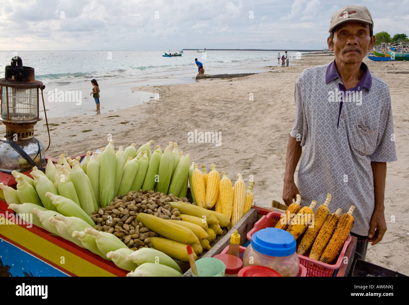 Mann verkauft gegrillten Maiskolben am Strand von Jimbaran Bali Indonesien Stockfoto