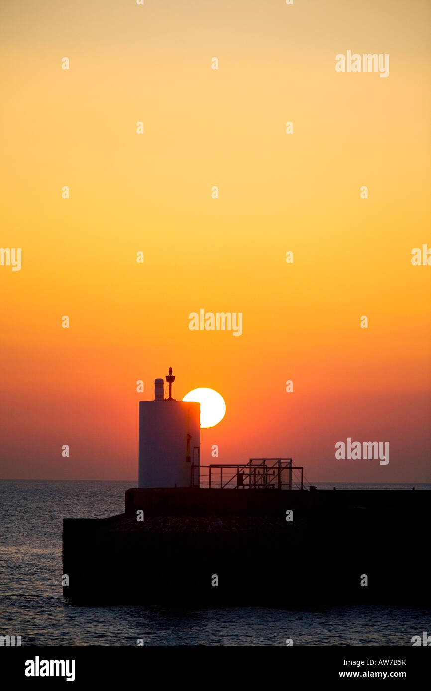 Untergehenden Sonne fällt hinter Leuchtturm am Pier Brighton Marina uk Stockfoto