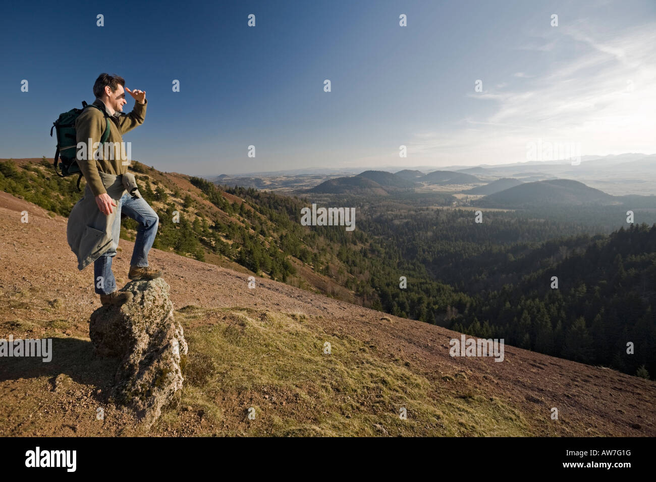 Ein Wanderer, der Blick auf die "Chaîne des Puys" aus dem Blickwinkel der "Puy de Lassolas". Randonneur Contemplant la Chaîne des Puys. Stockfoto