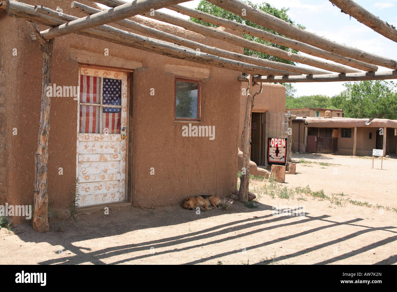 Adobe Gebäude mit Tür mit amerikanischen Flagge und Hand druckt Taos Pueblo New Mexico USA Stockfoto