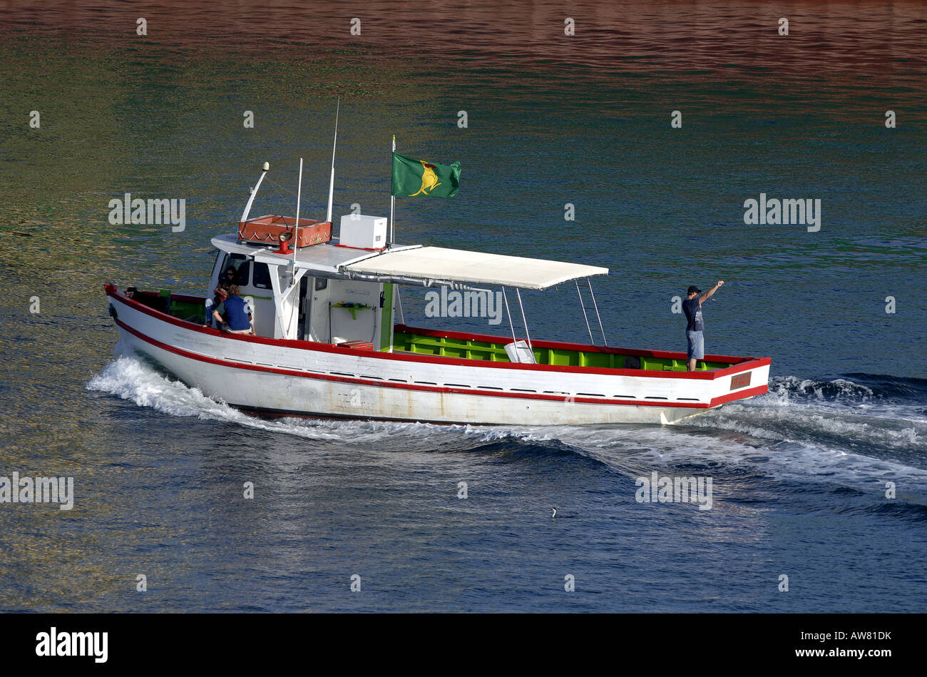 Ein kleines Fischerboot geht ein großes Containerschiff an einem schönen sonnigen Morgen im Hafen von Fremantle, Perth, Western Australia Stockfoto