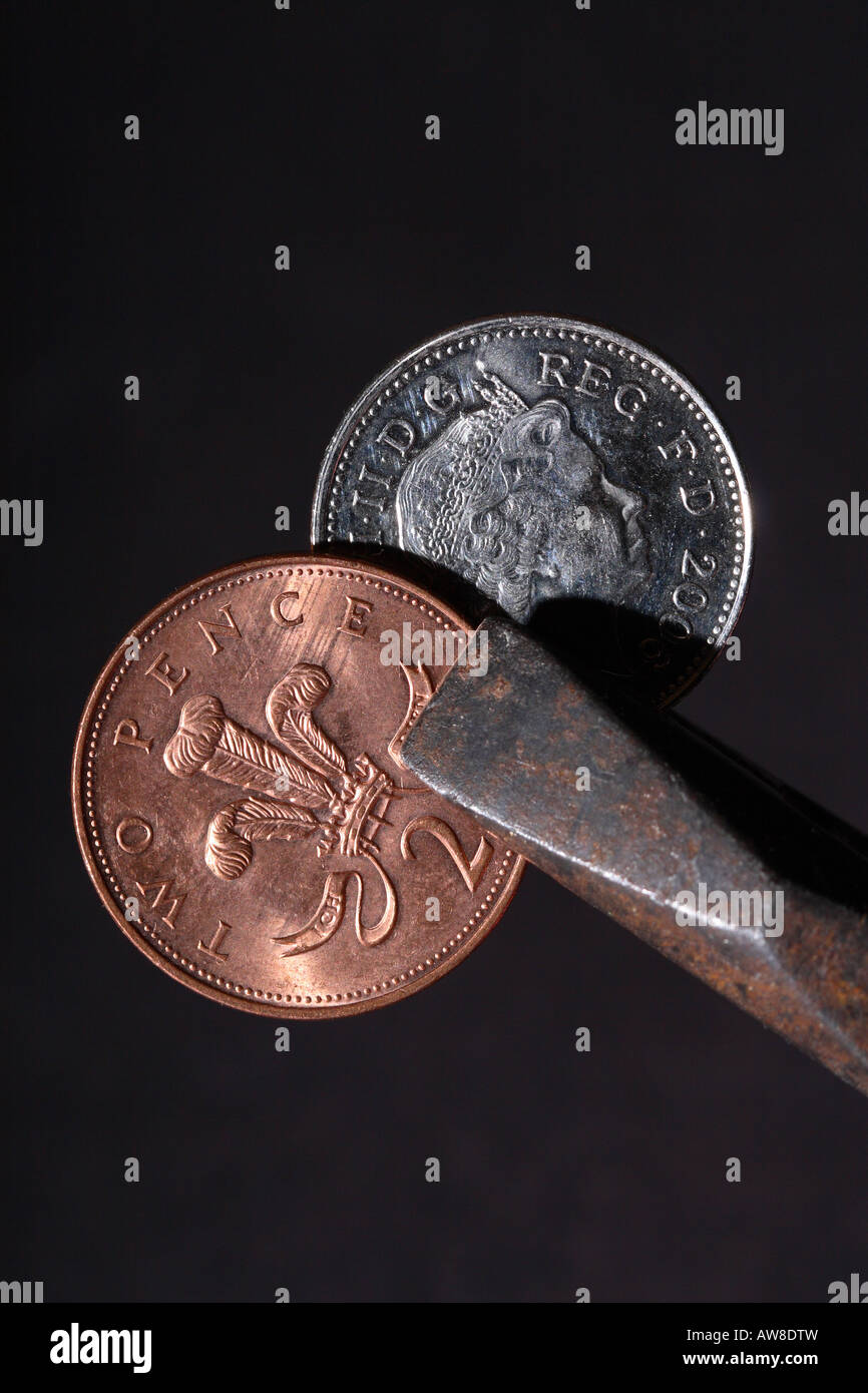 Britisches Geld 2P und 10P Pence Münze statt Zange Werkzeug-Preis-Schere Stockfoto