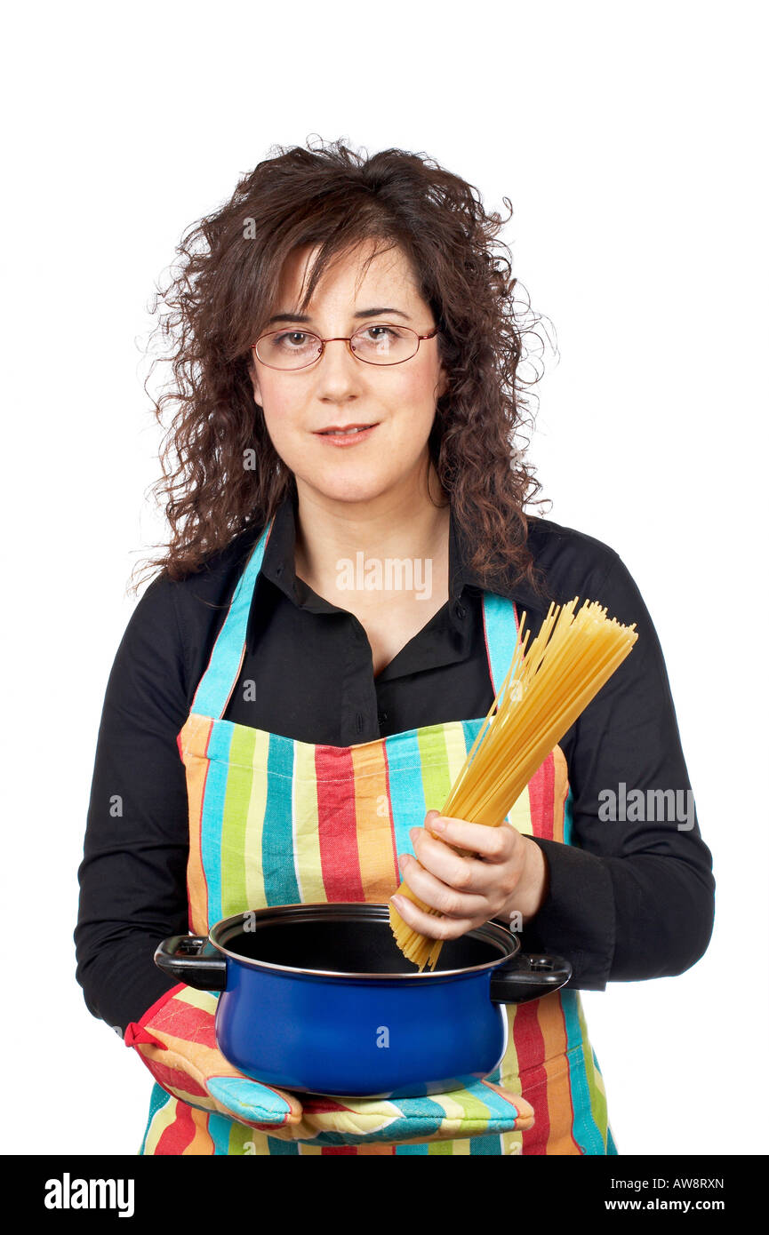 Hausfrau in Schürze, ein Spaghetti ungekocht in der blauen Pfanne einführt Stockfoto