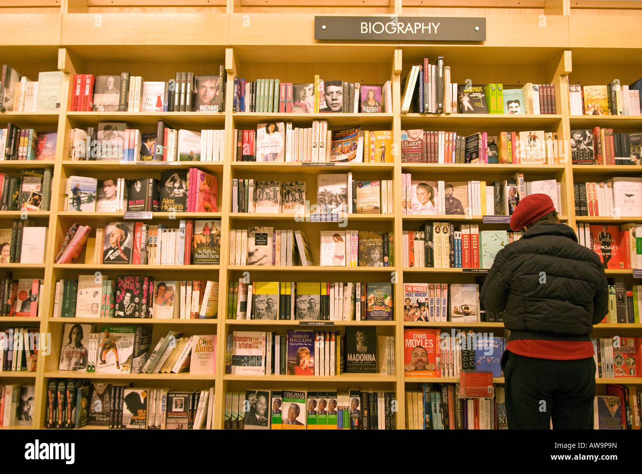 Frau, die Biografie durchgeht, im Borders Bookshop, Kingston, Surrey, Großbritannien. Stockfoto