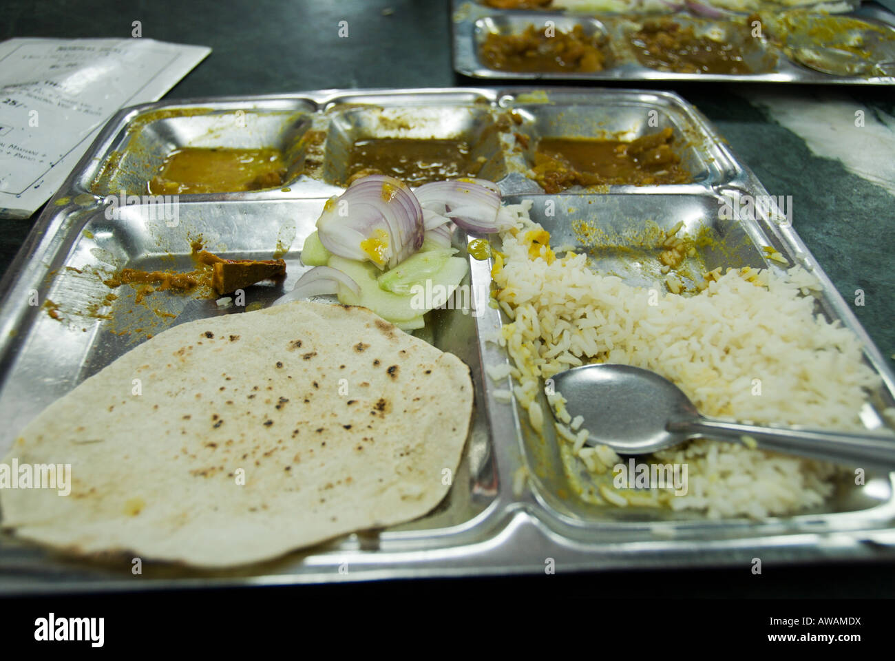 Eine Hälfte gegessen, einfache vegetarische Thali mit Edelstahl Löffel Chapati Salat und verschiedene Currys und Dhal Pahar Ganj Neu-Delhi Stockfoto