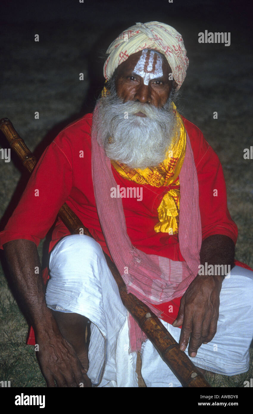 Rote Roben Saddhu mit bemaltem Gesicht warten auf Almosen in Indien Stockfoto