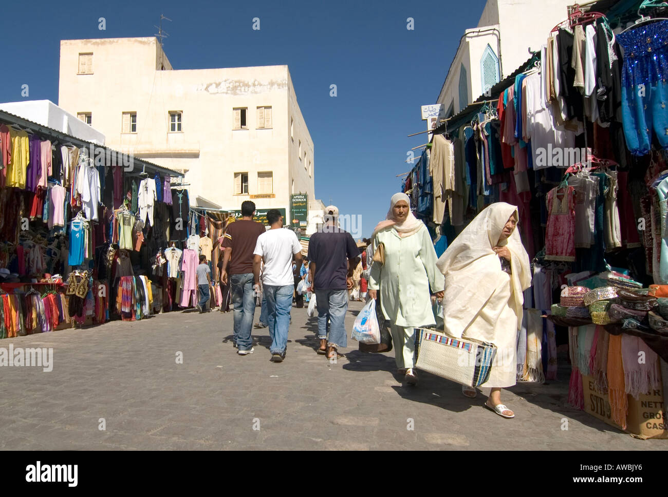 Traditionelle tunesische Frauen, verschleiert und in weiß gekleidet, Einkaufen in Kairouan Souk Markt, Tunesien. Stockfoto