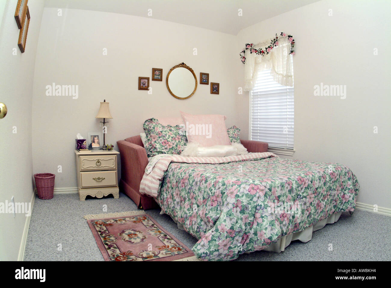 Blick auf ein gemütliches Bett mit einem floralen Bettdecke Stockfoto