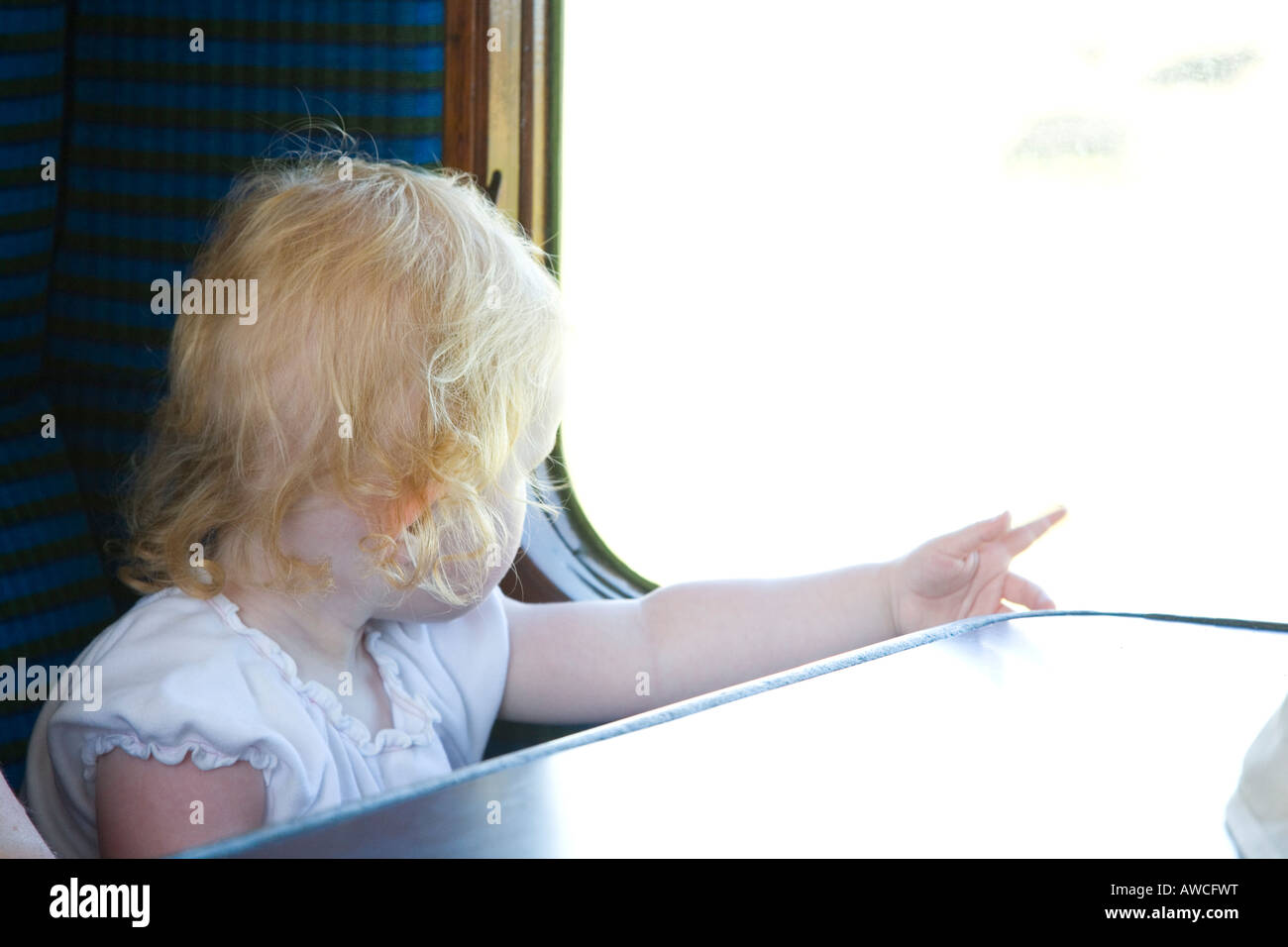 Weiblichen Kleinkind aus historischen Eisenbahn Wagen Fenster auf Landschaft zeigen Stockfoto