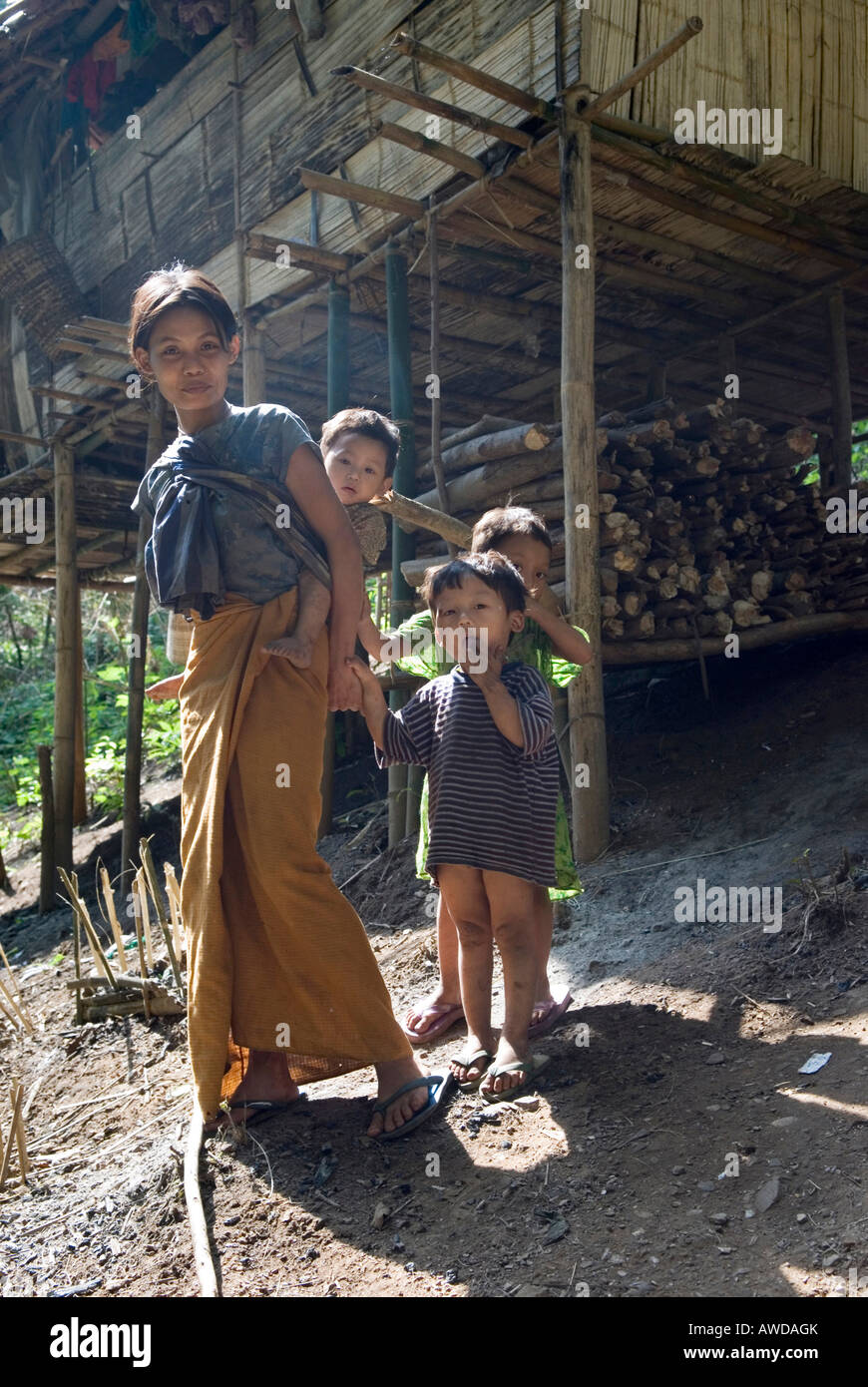 Flüchtling-Frau mit Kindern vor einem traditionellen Stelzenhaus, Flüchtlingslager Oh Win Hta, IDP-Gebiet grenzt an Thailand in der Nähe von Mae Stockfoto