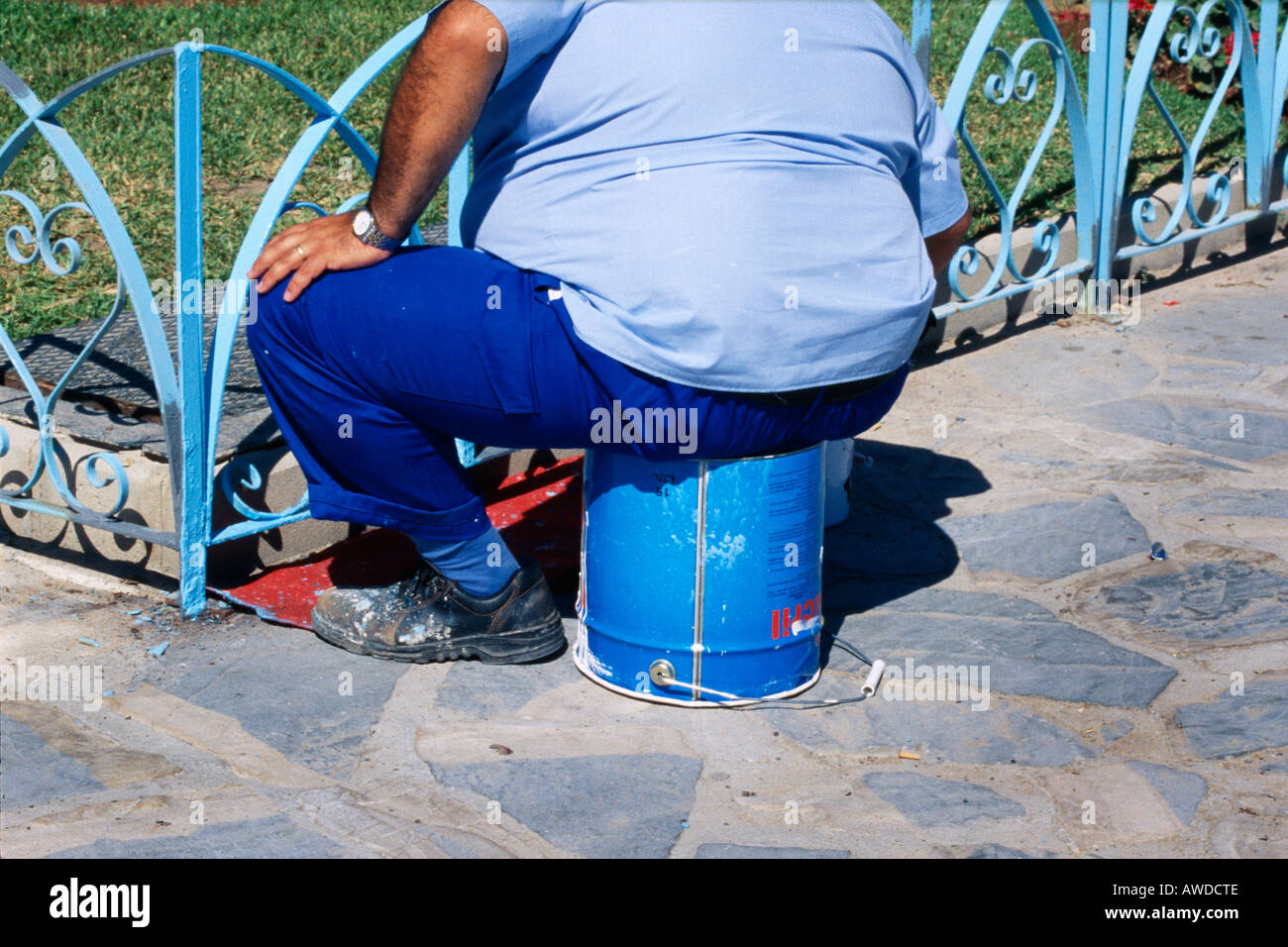 Mann Malerei Zaun sitzen auf leere Farbe Zinn Spanien Stockfoto